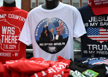 Among the souvenirs on sale are T-shirts printed with the photograph of Donald Trump defiantly pumping his fist after the assassination attempt / ©AFP