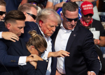 Secret Service agents shield former president Donald Trump as he is escorted off the stage following an attempted assassination / ©AFP