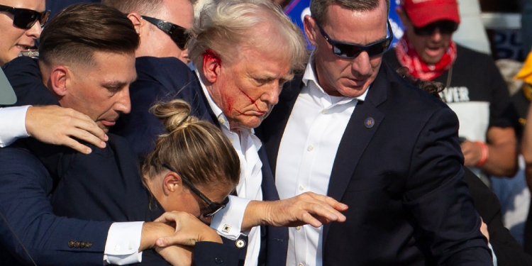 Secret Service agents shield former president Donald Trump as he is escorted off the stage following an attempted assassination / ©AFP