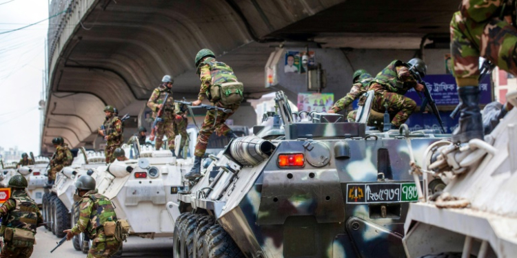 Bangladesh troops disembark armoured vehicles as they patrol the streets of the capital. ©AFP