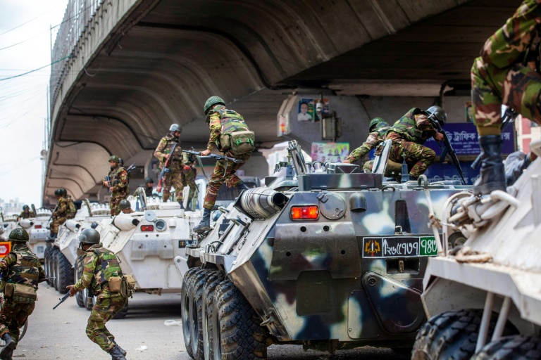 Bangladesh troops disembark armoured vehicles as they patrol the streets of the capital. ©AFP