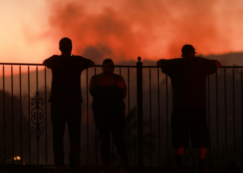 People watch as a wildfire burns close to properties in Riverside, California, on July 21, 2024. ©AFP