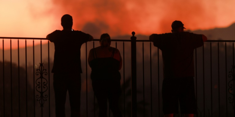 People watch as a wildfire burns close to properties in Riverside, California, on July 21, 2024. ©AFP