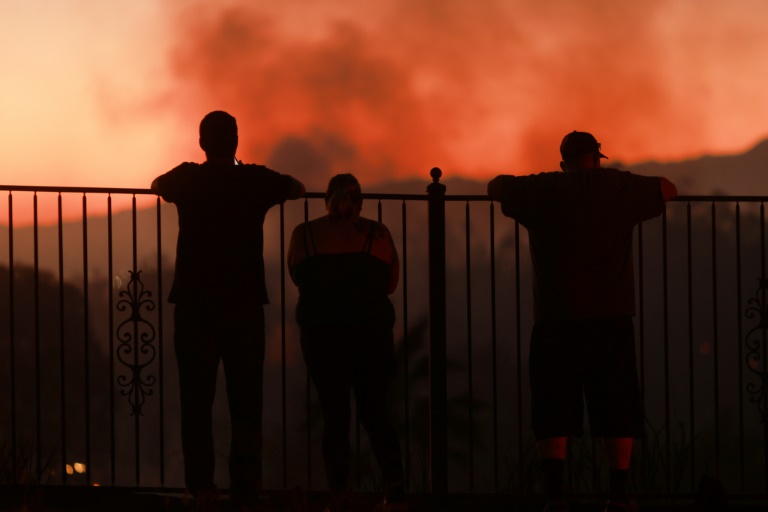 People watch as a wildfire burns close to properties in Riverside, California, on July 21, 2024. ©AFP