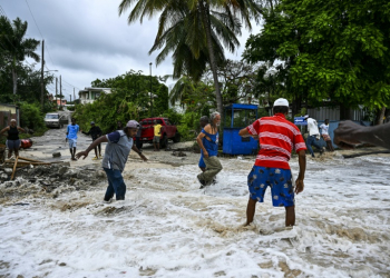 People walk through flooding from seawater after the passage of Hurricane Beryl in the parish of Saint James, Barbados. ©AFP