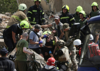 Emergency and rescue personnel retrieve a wounded woman from the rubble of a residential building following a Russian aerial attack in the Ukrainian capital of Kyiv. ©AFP