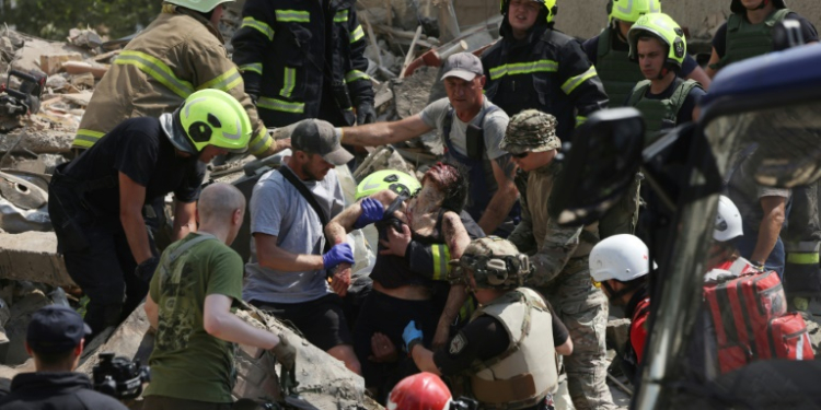 Emergency and rescue personnel retrieve a wounded woman from the rubble of a residential building following a Russian aerial attack in the Ukrainian capital of Kyiv. ©AFP