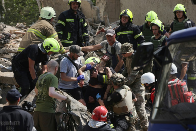 Emergency and rescue personnel retrieve a wounded woman from the rubble of a residential building following a Russian aerial attack in the Ukrainian capital of Kyiv. ©AFP