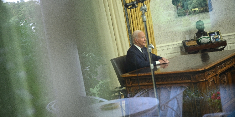 Seen through a window, US President Joe Biden speaks during an address to the nation from the Oval Office of the White House in Washington, DC on July 14, 2024.  / ©AFP