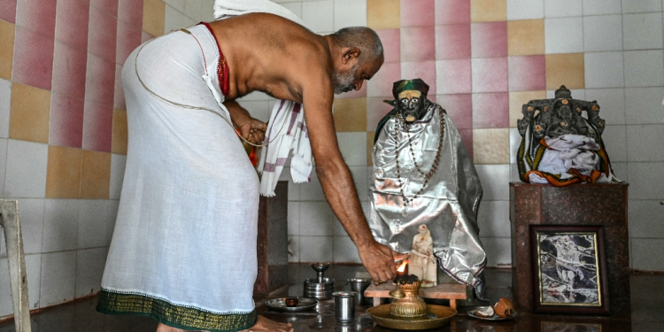 Hindu priest Subhramanya Sharma lights a lamp while praying for the victory of US vice president candidate JD Vance at a temple in Vadluru, ancestral home of Vance's wife Usha / ©AFP