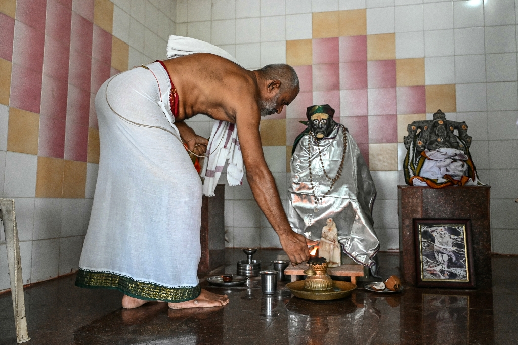 Hindu priest Subhramanya Sharma lights a lamp while praying for the victory of US vice president candidate JD Vance at a temple in Vadluru, ancestral home of Vance's wife Usha / ©AFP