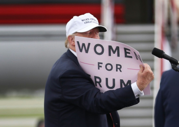 Donald Trump holds a sign that reads 'Women for Trump' during his 2016 presidential campaign, which was beset by scandal over his treatment of women. ©AFP