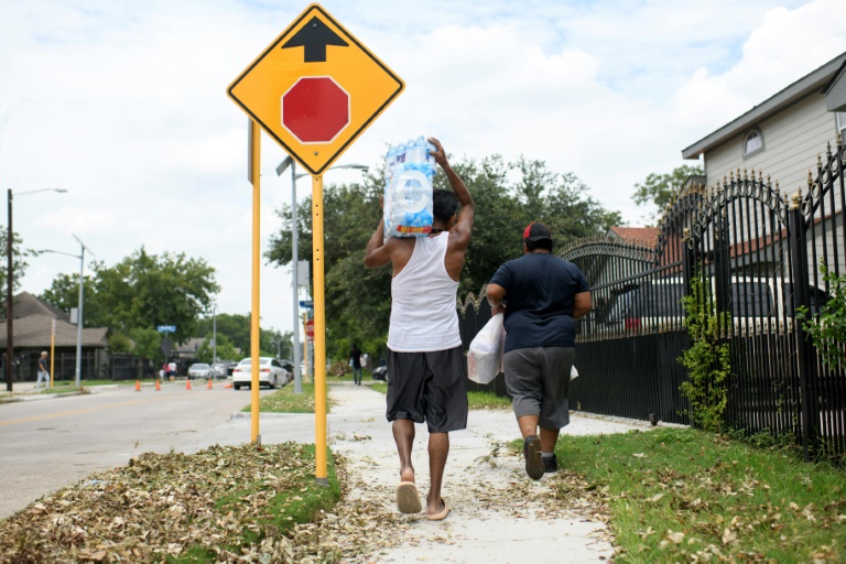 A man carries a container of water from a distribution center in Houston, Texas, on July 11, 2024. ©AFP