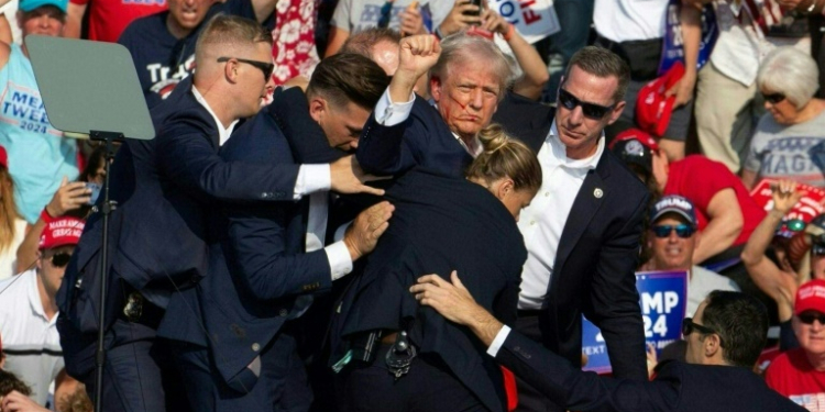 Republican presidential candidate Donald Trump surrounded by Secret Service agents after an assassination attempt in Butler, Pennsylvania. ©AFP