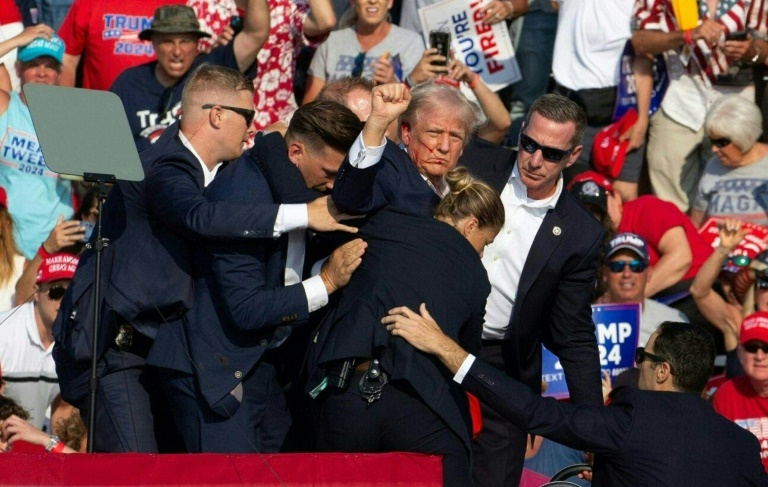 Republican presidential candidate Donald Trump surrounded by Secret Service agents after an assassination attempt in Butler, Pennsylvania. ©AFP