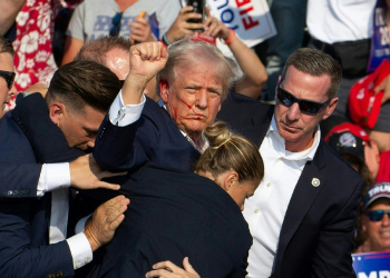 Republican candidate Donald Trump is seen with blood on his face surrounded by secret service agents as he is taken off the stage / ©AFP