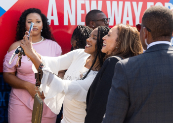 Democratic presidential candidate Kamala Harris took photos with supporters by her campaign bus / ©AFP