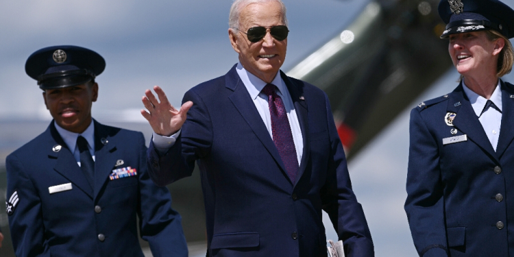 US President Joe Biden (C) is welcomed by Air Force Colonel Angela Ochoa (R) as he arrives to board Air Force One at Joint Base Andrews in Maryland on August 19, 2024. The Bidens are travelling to Chicago for the Democratic National Convention / ©AFP