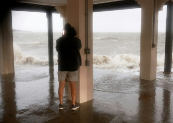 A man checks on his neighborhood as high winds, rain and storm surge from Hurricane Debby inundate  Cedar Key, Florida. ©AFP