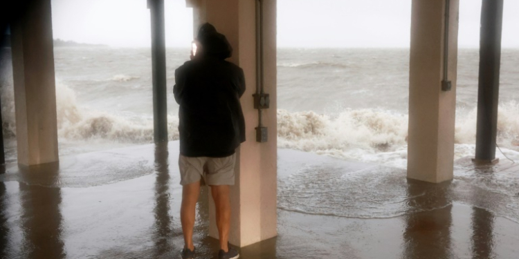 A man checks on his neighborhood as high winds, rain and storm surge from Hurricane Debby inundate  Cedar Key, Florida. ©AFP