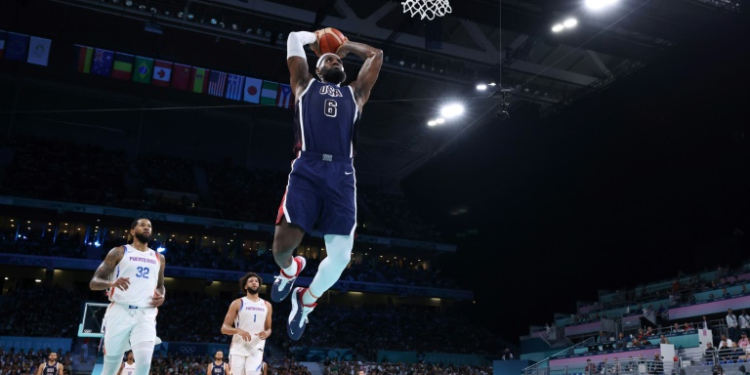 Team USA superstar LeBron James throws down a dunk in a victory over Puerto Rico in group play at the Paris Olympics. ©AFP