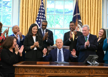 US President Joe Biden, joined by civil rights leaders, community members, and elected officials, signs a proclamation to designate the Springfield 1908 Race Riot National Monument, in the Oval Office of the White House in Washington, DC, August 16, 2024. ©AFP