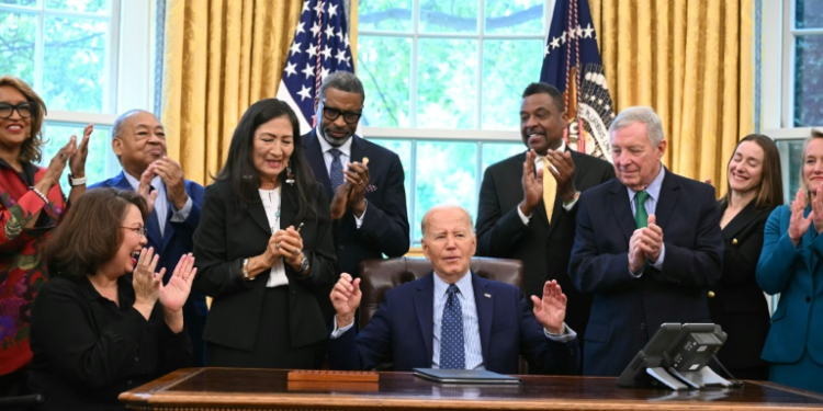 US President Joe Biden, joined by civil rights leaders, community members, and elected officials, signs a proclamation to designate the Springfield 1908 Race Riot National Monument, in the Oval Office of the White House in Washington, DC, August 16, 2024. ©AFP