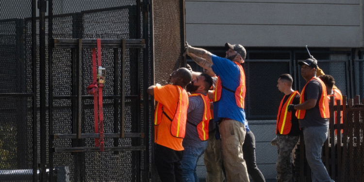 Workers install security fencing around the United Center as they prepare for the start of the Democratic National Convention on August 12, 2024, in Chicago, Illinois / ©AFP