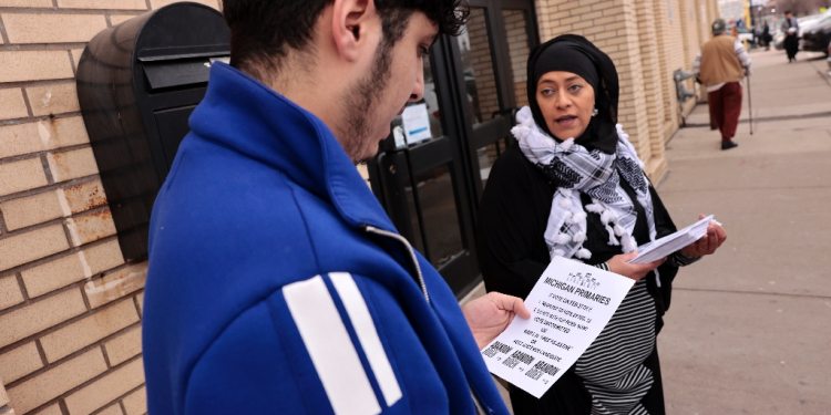 Samra'a Luqman hands out fliers outside the American Moslem Society Mosque / ©AFP