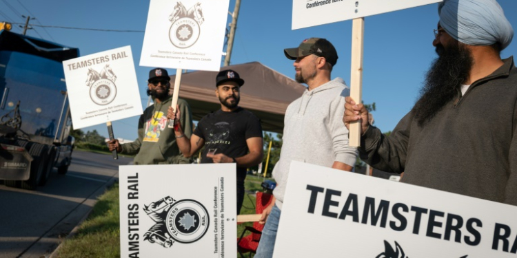 Locked out railway workers picket outside the CN Rail Brampton yard in Ontario province . ©AFP