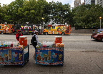 Migrants from Ecuador sell goods in Chicago -- migrants often have to wait months before they can apply for a work permit, and their cases are taking longer and longer due to excessive demand on the immigration court system / ©AFP