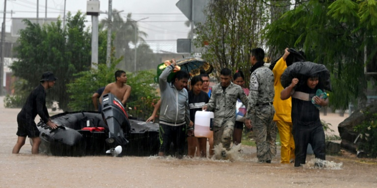 Mexican police and members of the National Guard help residents of Acapulco after Hurricane John caused major flooding. ©AFP