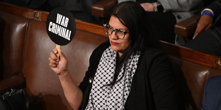 In the cartoon, a woman identified as Rep. Tlaib is seen sitting at a desk next to an exploding electronic device / ©AFP