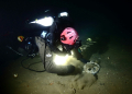 A handout image from Atlantic Wreck Salvage shows diver Joe Mazraani fanning away sand to reveal a 'deadeye' used as part of the sail rigging of Le Lyonnais. ©AFP