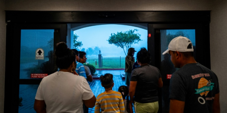 Families watch Hurricane Francine from the entrance of their hotel on September 11, 2024 in Houma, Louisiana. ©AFP