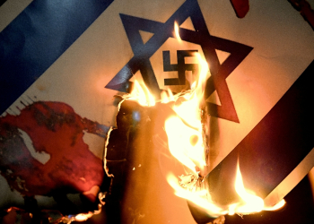 An Israeli flag with a swastika superimposed on the Star of David is burned at a pro-Palestinian protest in Istanbul / ©AFP