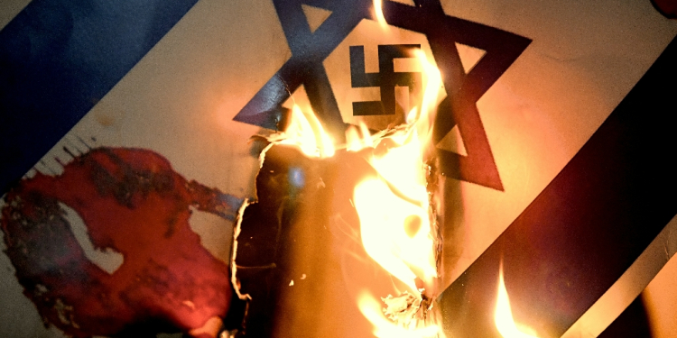 An Israeli flag with a swastika superimposed on the Star of David is burned at a pro-Palestinian protest in Istanbul / ©AFP