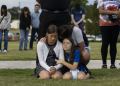 A mother and her children bow their heads in prayer at a vigil for the victims of the Apalachee High School shooting in Winder, Georgia. ©AFP