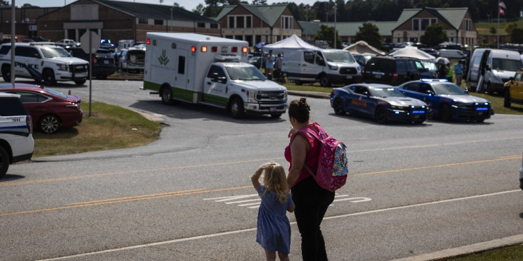 A girl and her mother watch as law enforcement and first responders surround Apalachee High School in Winder, Georgia, on September 4, 2024 / ©AFP