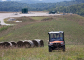 Diana Petrie, left, and her father George Wherry drive through hay fields after giving a tour of the natural gas well site on their farm in West Bethlehem Township, in Washington County, Pennsylvania / ©AFP