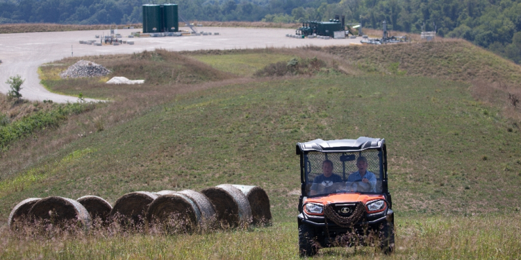 Diana Petrie, left, and her father George Wherry drive through hay fields after giving a tour of the natural gas well site on their farm in West Bethlehem Township, in Washington County, Pennsylvania / ©AFP