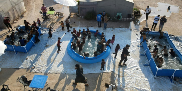 Displaced Syrian children play in swimming pools set up by the Smile Younited charity in the rebel-held part of Aleppo province on July 27, 2024. ©AFP