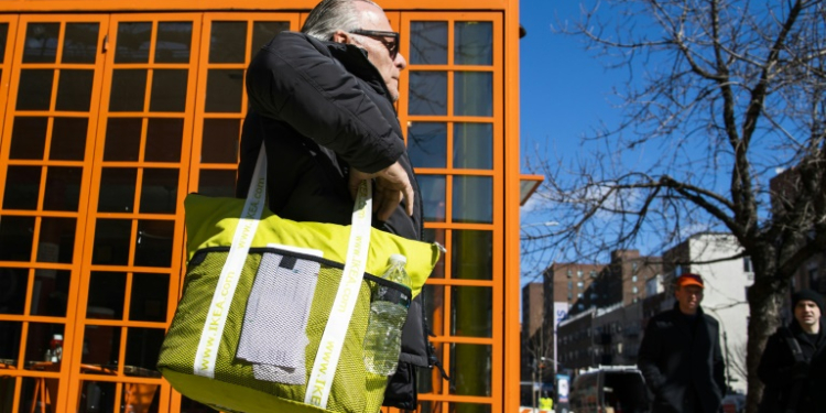 A customer carries his own reusable bag after shopping at a local supermarket on March 1, 2020 in New York City. ©AFP