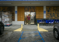 A person walks into a store boarded up with wood as preparations are made for the arrival of Hurricane Helene, in Steinhatchee, Florida, on September 25, 2024. ©AFP