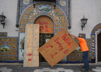 Contractors put plywood over the windows of the historic Columbia Restaurant in the Ybor City area of Tampa ahead of Hurricane Milton's expected landfall in Florida / ©AFP