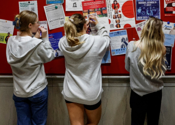 Students fill out registration forms as they take advantage of early voting in the 2024 US presidential election at a polling place at the University of Wisconsin-Madison / ©AFP