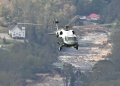 Marine One, carrying US President Joe Biden, flies above a storm impacted area near Asheville, North Carolina / ©AFP