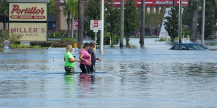 People walk through flooded streets in the Southeast Seminole Heights neighborhood of Tampa, Florida, inundated by Hurricane Milton, on October 10, 2024. ©AFP