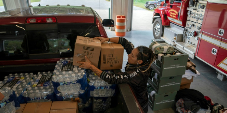 A volunteer unloads relief supplies in North Carolina on October 3, 2024, after the passage of Hurricane Helene made drinking water a valuable commodity. ©AFP