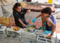 Displaced children eat a cooked meal in their tent at Gaza City's damaged Yarmouk stadium on October 14, 2024. ©AFP